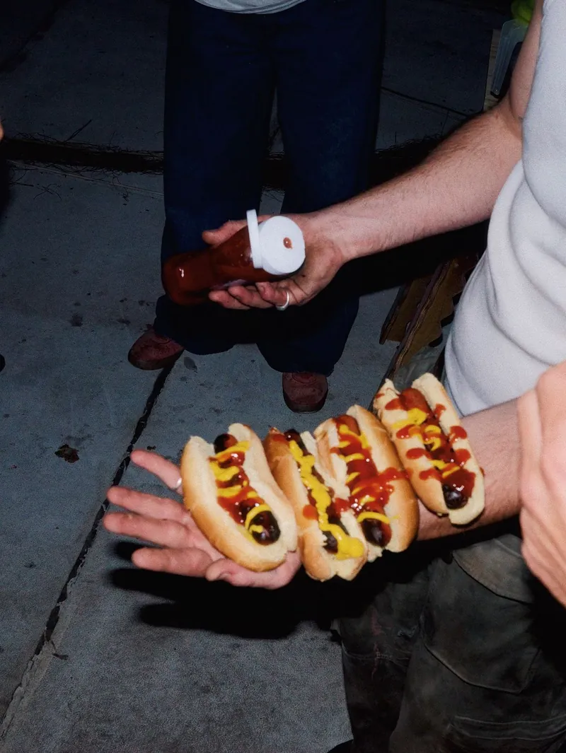 A handful of dressed hotdogs passed across at the truck